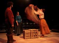 Actors on stage during the 2010 production of Vinegar Tom. A woman throws a cloth over a box | Photo courtesy of Stephan Golux
