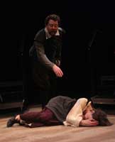 Actors on stage during the 2010 production of Vinegar Tom. A man reaches down towards a woman who lay on the ground | Photo courtesy of Stephan Golux
