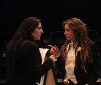 Actors on stage during the 2010 production of Vinegar Tom. Two actresses in suits point at each other in recognition and confusion| Photo courtesy of Stephan Golux