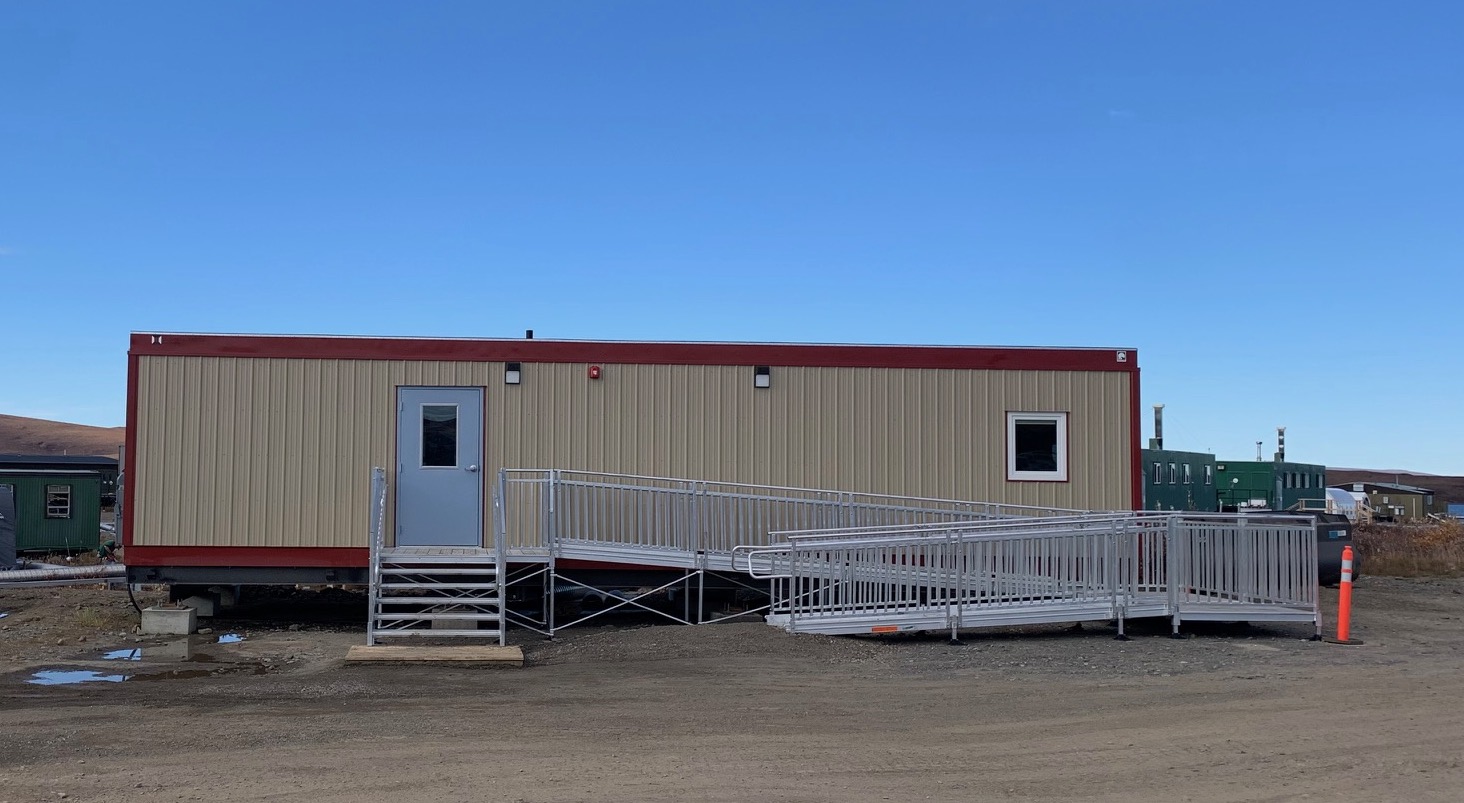 Toolik Field Station new medical clinic is a single-story modular unit with beige siding and red trim and features an ADA ramp and stairs in front.
