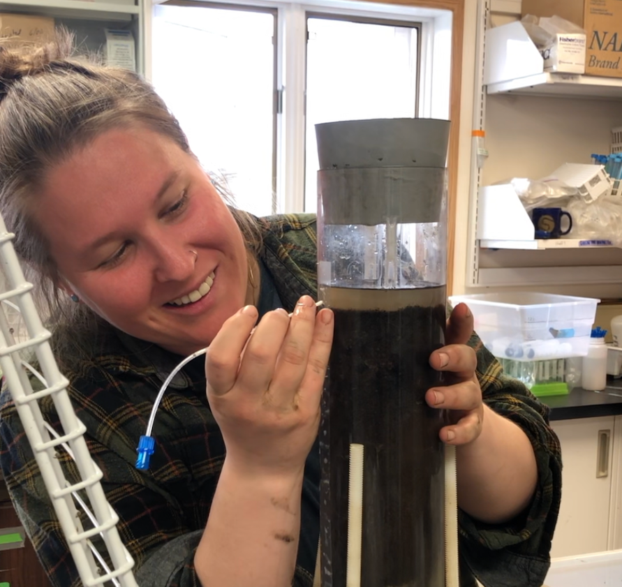 woman collecting porewater from sediment core in lab
