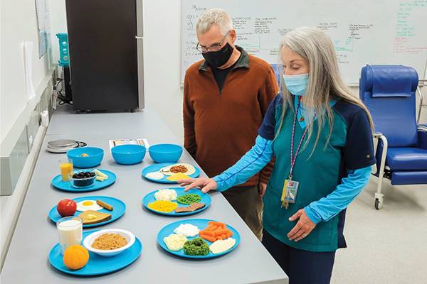 Ron Woolf, a research subject in an ongoing nutrition study at UAF, reviews plastic food models that display possible meal choices with the help of clinical coordinator Sheri Coker.