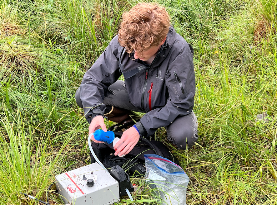 Ryan at Smith Lake collecting filtered lake water. The water will be analyzed in the lab for absorbance and fluorescence of organic matter, providing some context for the project.