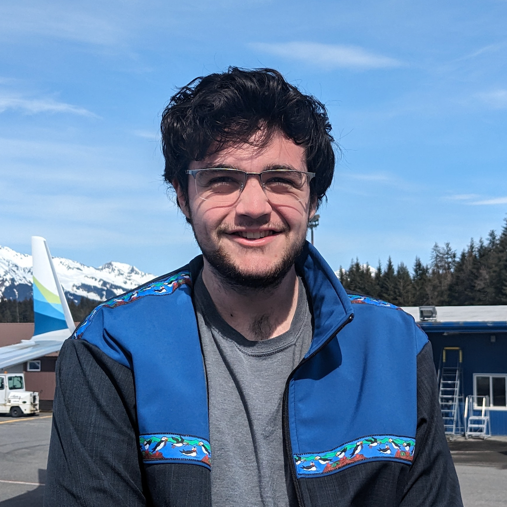 Adrian standing outside in front of a plane