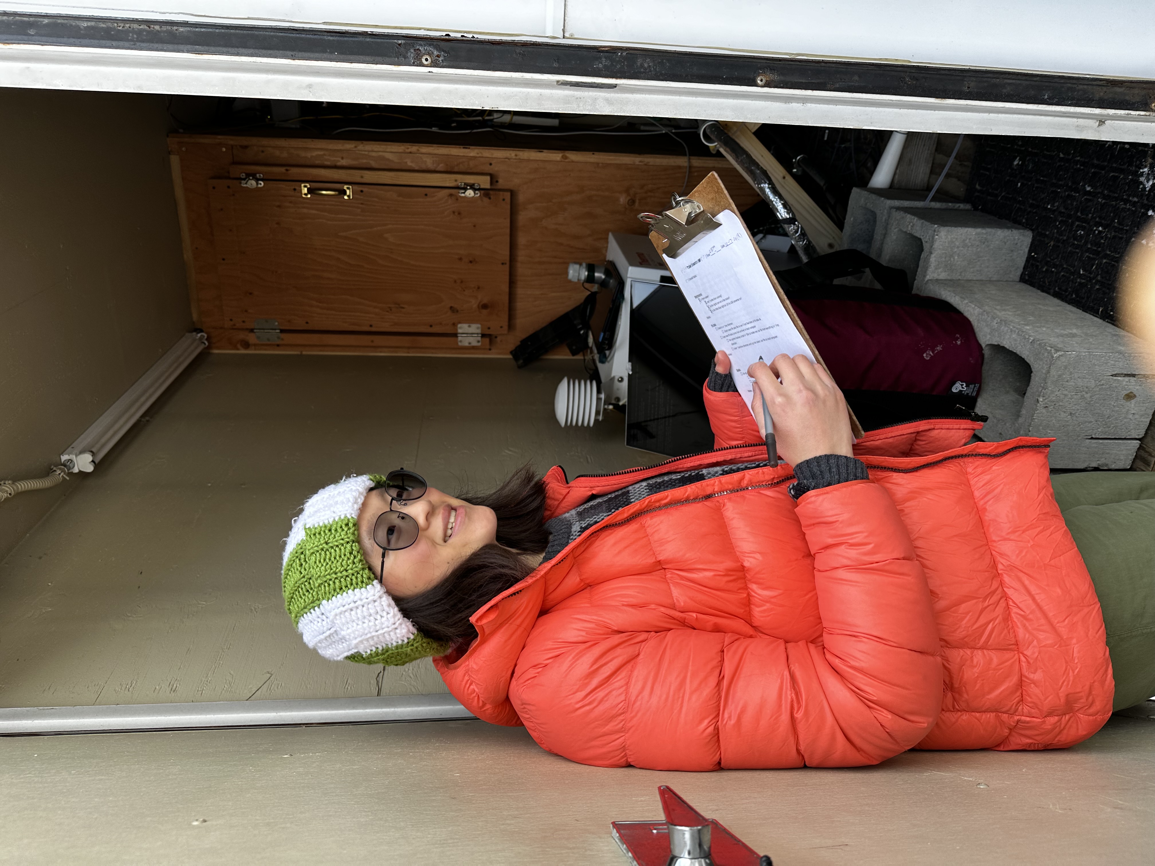 Anastasia in the trailer tower transferring measurements to the local computer. Particulate matter, CO2, and temperature data has to be moved and organized after logging in order to be analyzed.