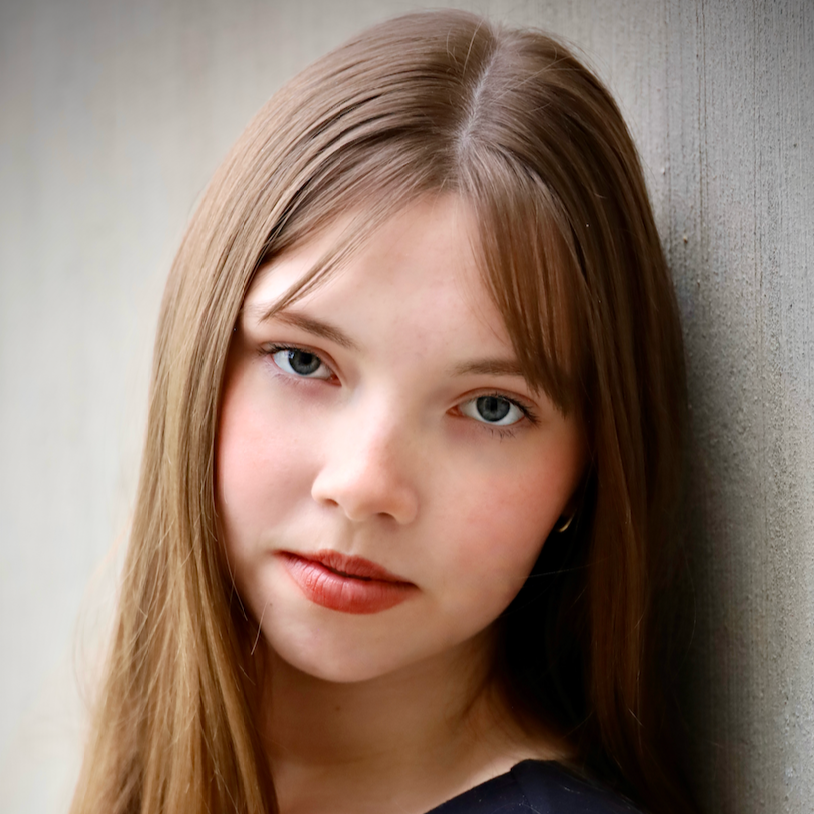 Hannah Greene headshot photo in front of a blank wall