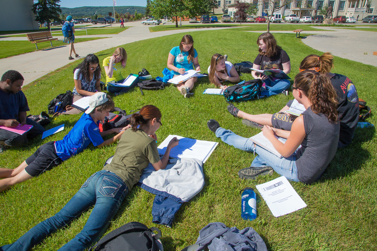 Students study for their summer sessions biology course in the grass outside the Bunnell Buildng on a nice July afternoon. | UAF Photo by Todd Paris