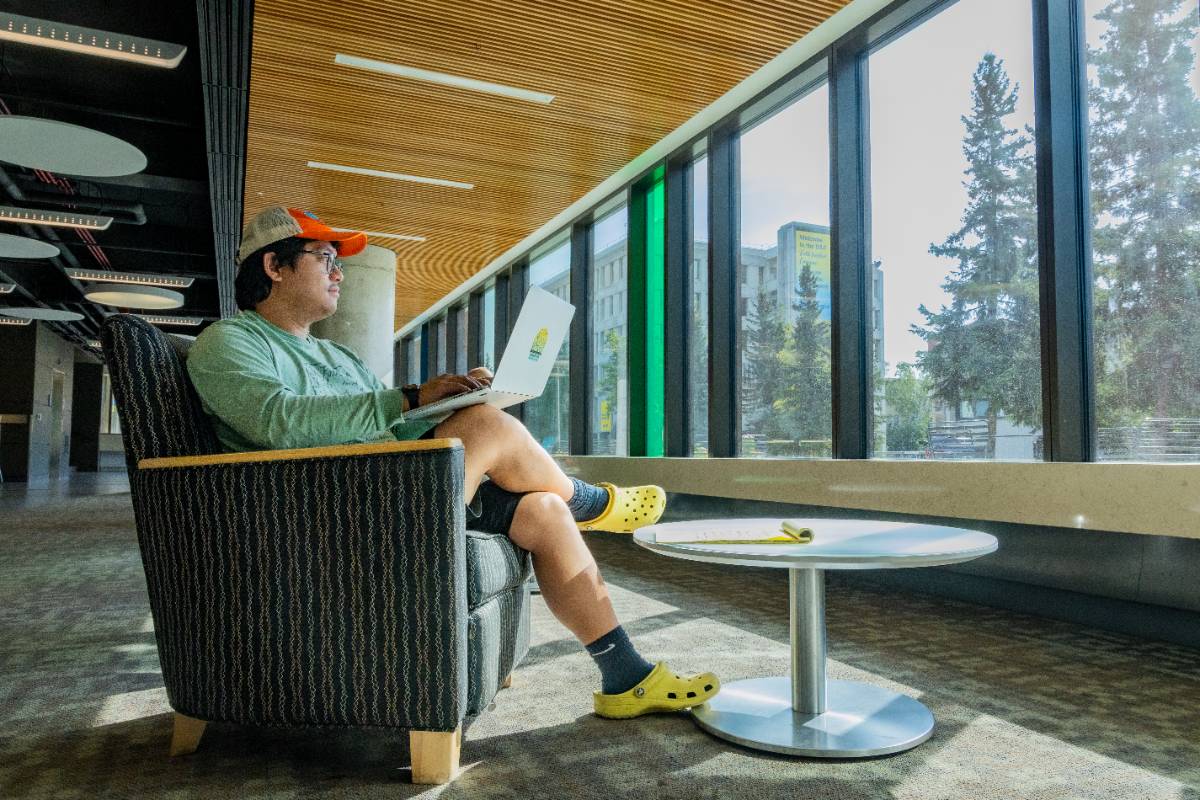 UAF student with laptop seated in the Arctic Java coffee shop at the Wood Center student union.